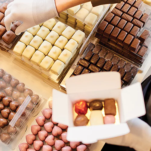 image of our leonidas chocolates counter and chocolates being picked for a choose your own ballotin
