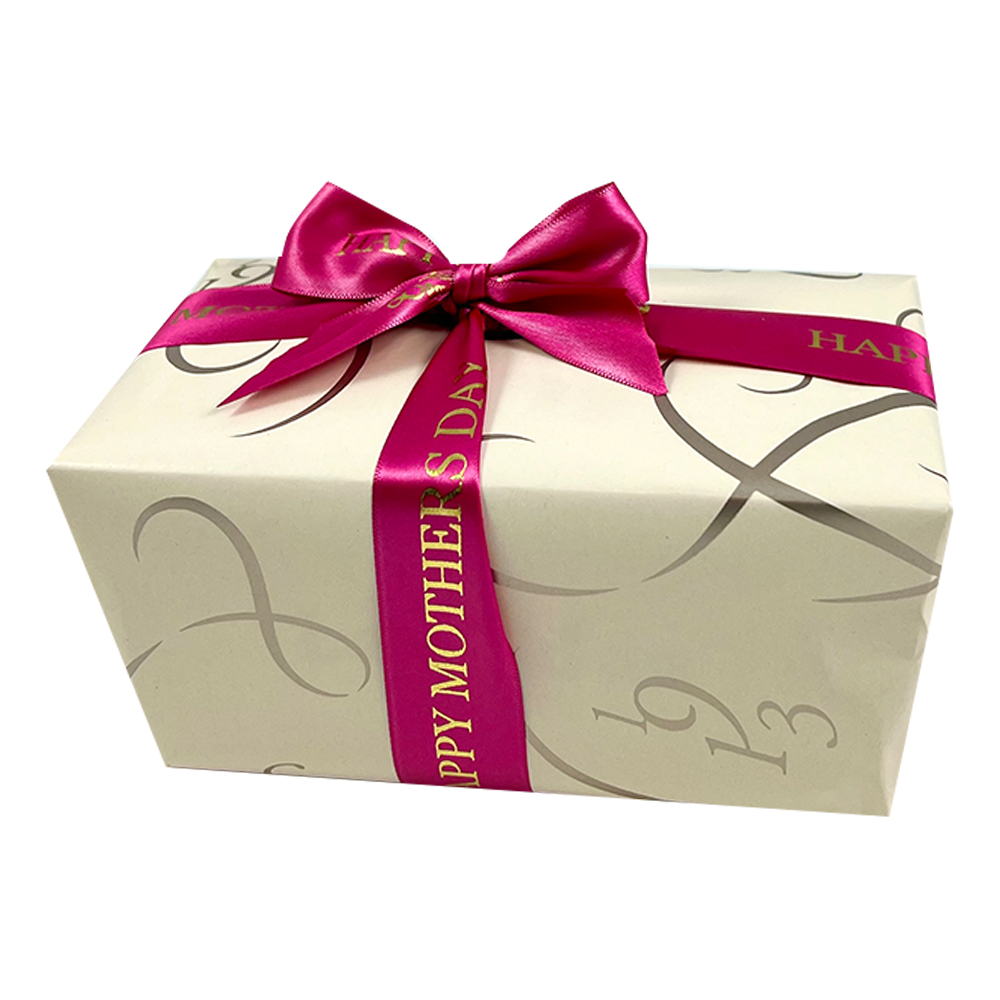 A Box Of Chocolates Wrapped in Champagne Coloured Paper and pink Mothers Day Ribbon