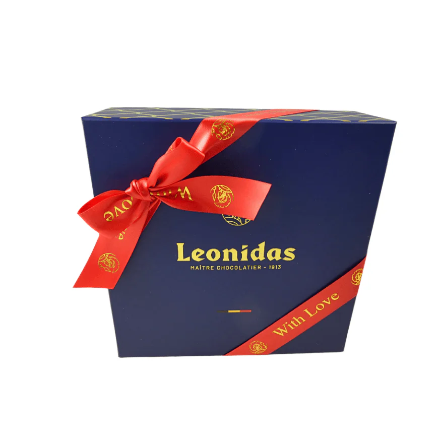 A large blue Leonidas gift box wrapped with a red ribbon with the words, "With Love."