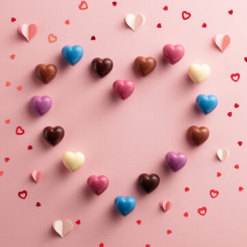 Leonidas chocolate hearts arranged into a larger heart and a pink background.
