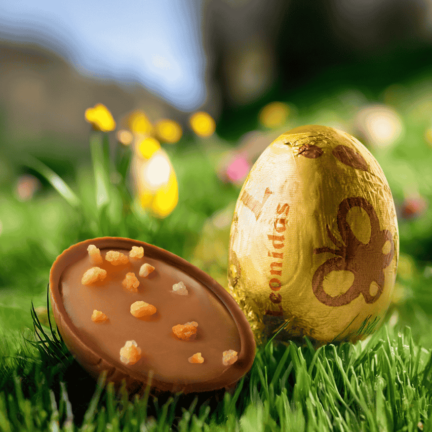 a gold wrapped leonidas mini egg and a egg cut in half to show the center