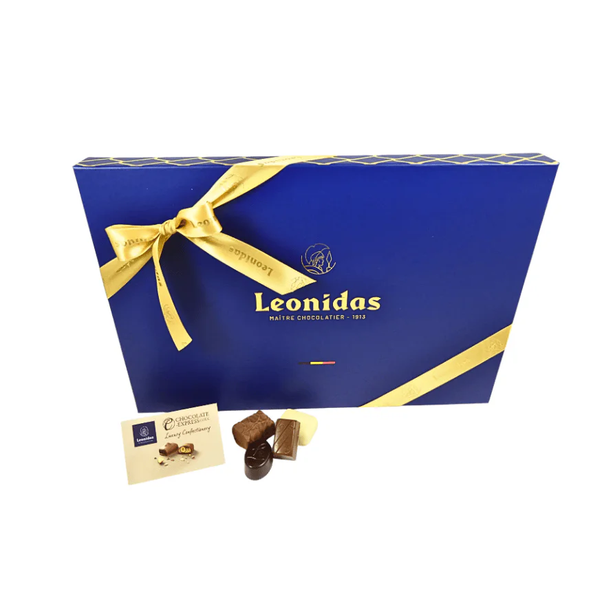 A large blue box of Leonidas chocolates wrapped with gold ribbon.