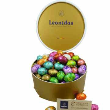a gold round leonidas gift box filled with colourful foil wrapped mini eggs