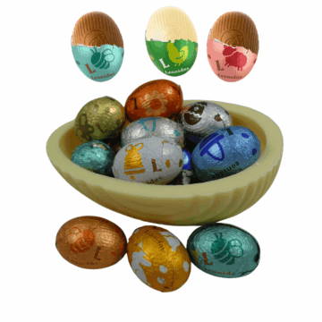 a small white chocolate egg shell filled with foild wrapped mini eggs