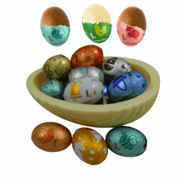 a small white chocolate egg shell filled with foild wrapped mini eggs