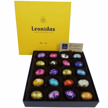 open gift box filled with foil wrapped mini eggs with a yellow lid